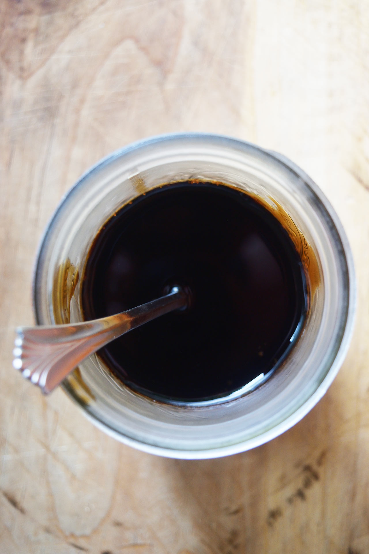 An overhead view of a partially full jar filled with balsamic glaze.