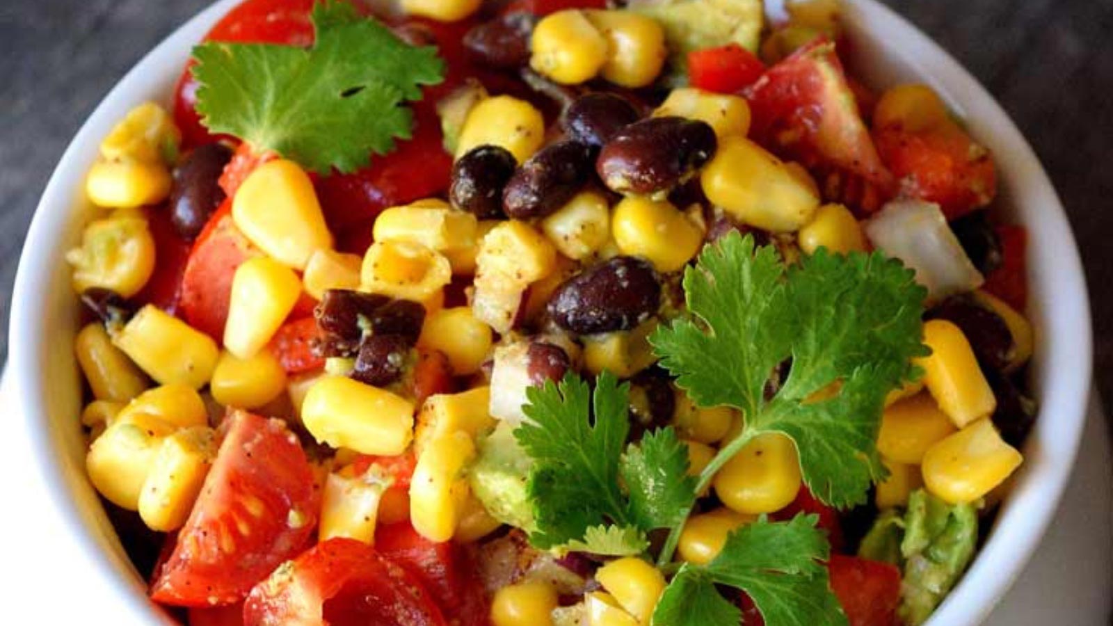 A white bowl filled with black bean corn salad.