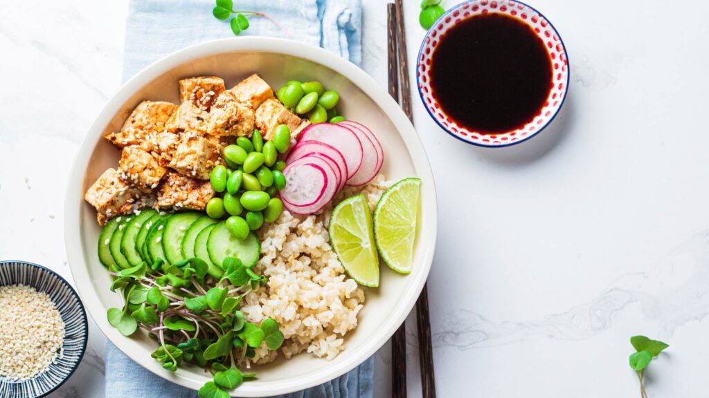 Overhead view of a brown rice buddha bowl with fresh veggies.