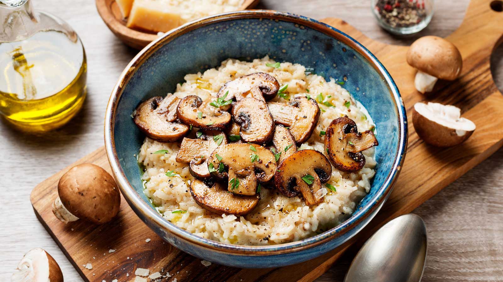 Brown rice in a bowl with sautéd mushrooms ontop.