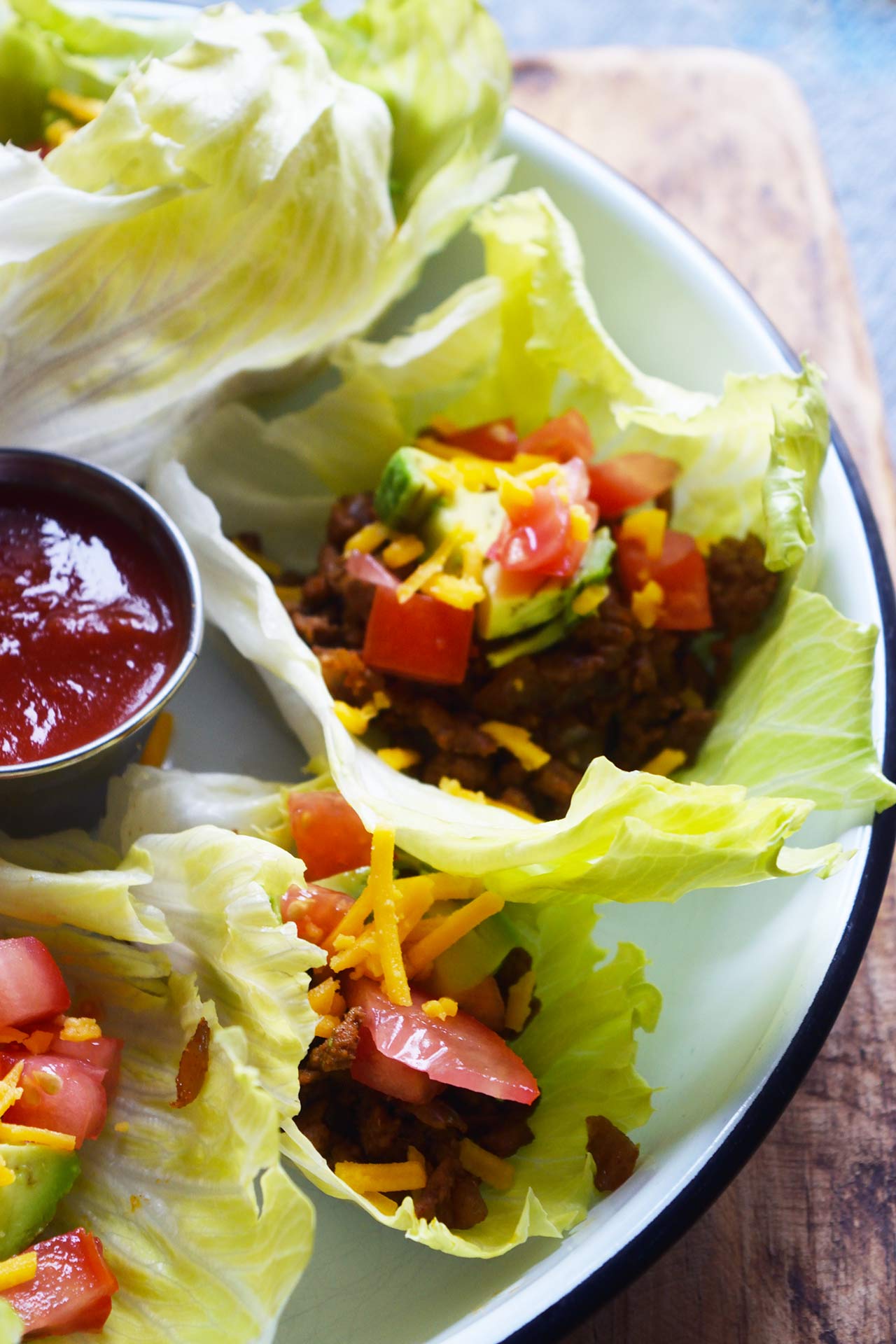 Side angle focus of a white, round platter filled with Taco Lettuce Wraps.