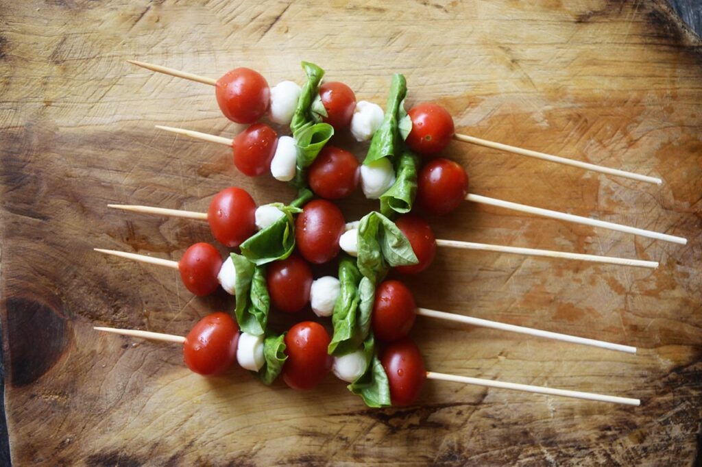 An overhead view of a line of Caprese Skewers just assembled.