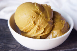 Closeup view of a white bowl filled with scoops of coffee ice cream.