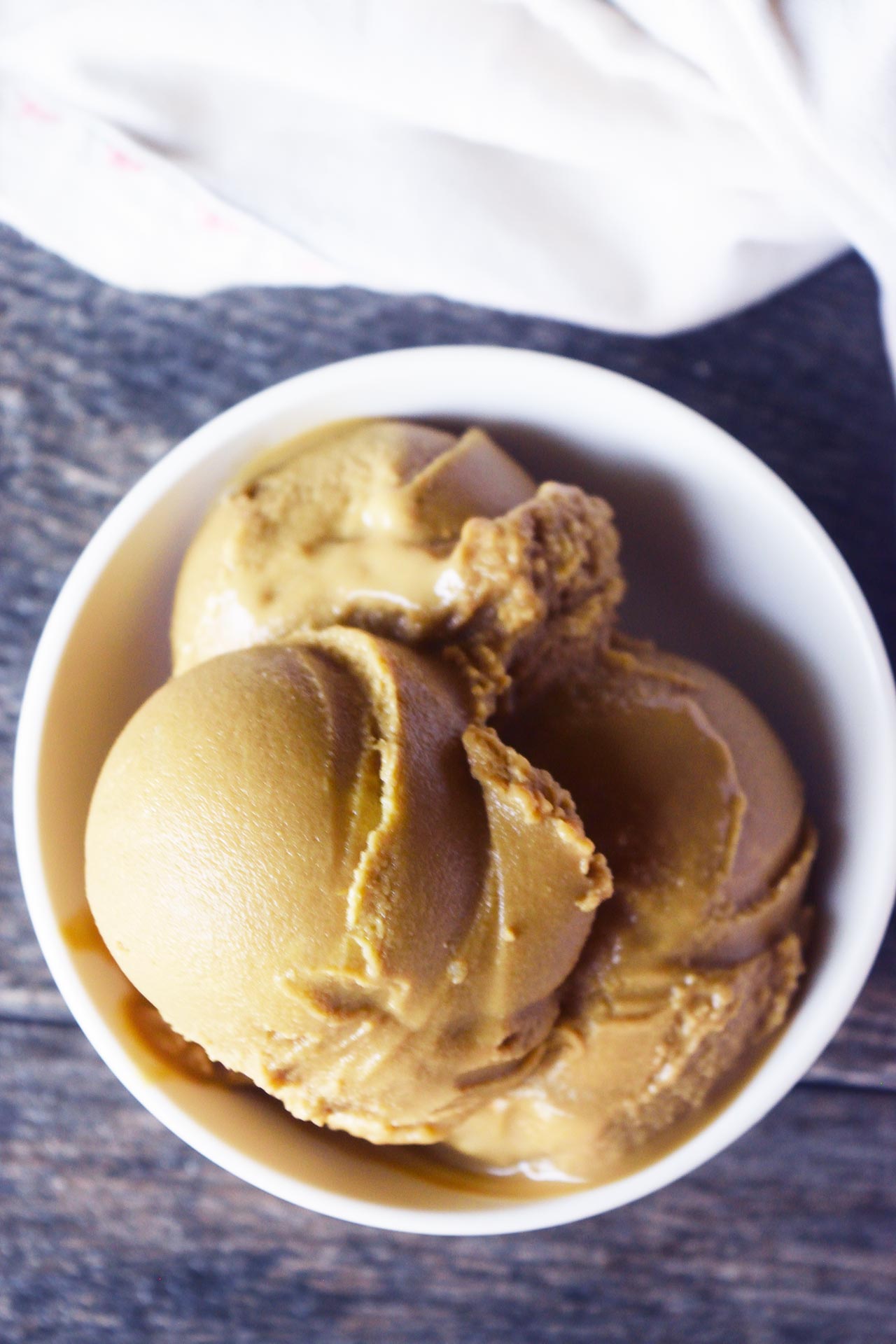 An overhead view of a white bowl filled with coffee ice cream.