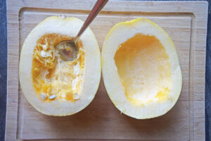 Two spaghetti squash halves with one scraped clean of seeds.