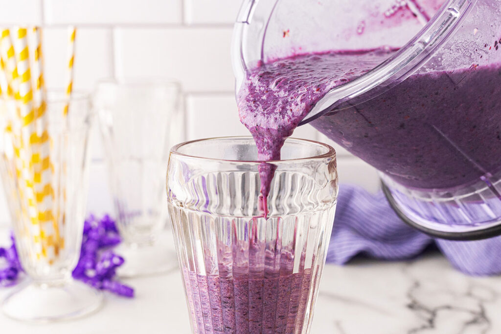 Pouring blended Grimace Shake into glasses.