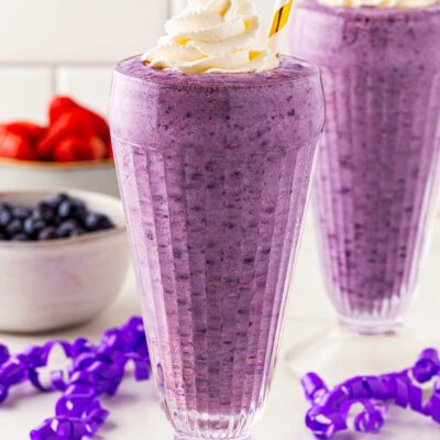 Two glasses on a countertop filled with Grimace Shake.