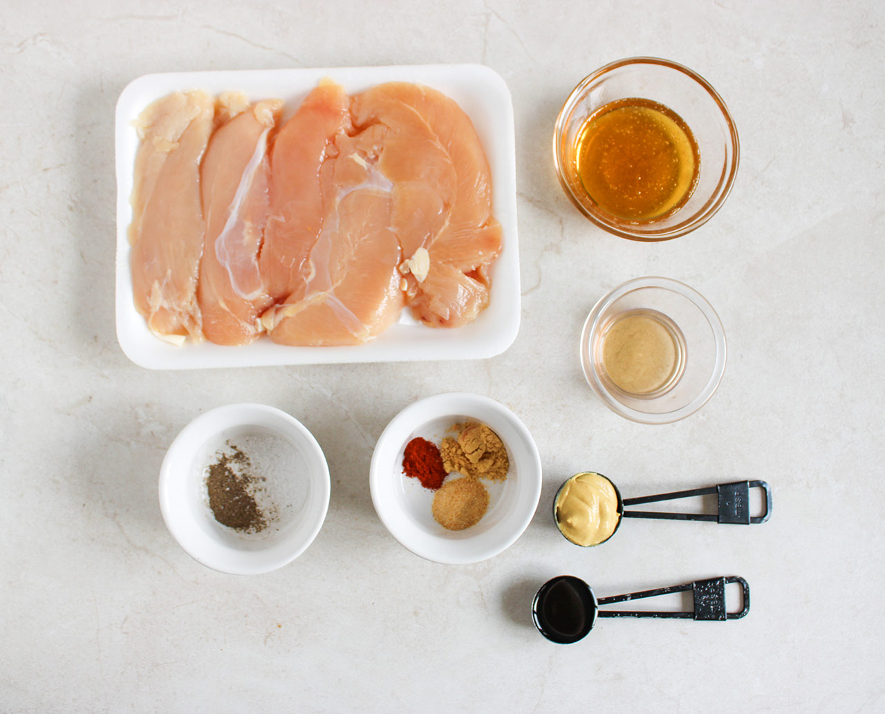 Ingredients for this Honey Mustard Chicken Tenders Recipe on a white surface.
