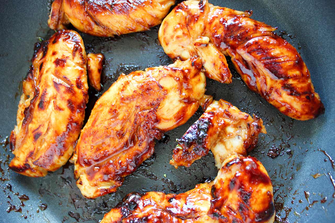 Honey Mustard Chicken Tenders cooking in a skillet.
