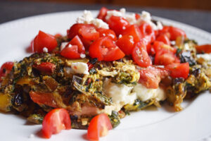 A closeup of a Mediterranean Omelet on a white plate.