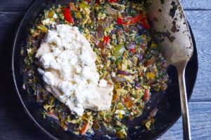Hummus and crumbled feta spooned over one half of the egg and veggie pancake.