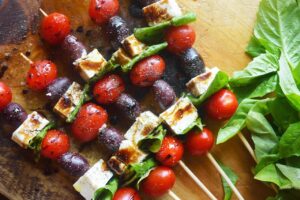 An overhead view of Mediterranean Skewers lined up on a wood surface.