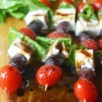 A front view of Mediterranean Skewers on a wood cutting board.