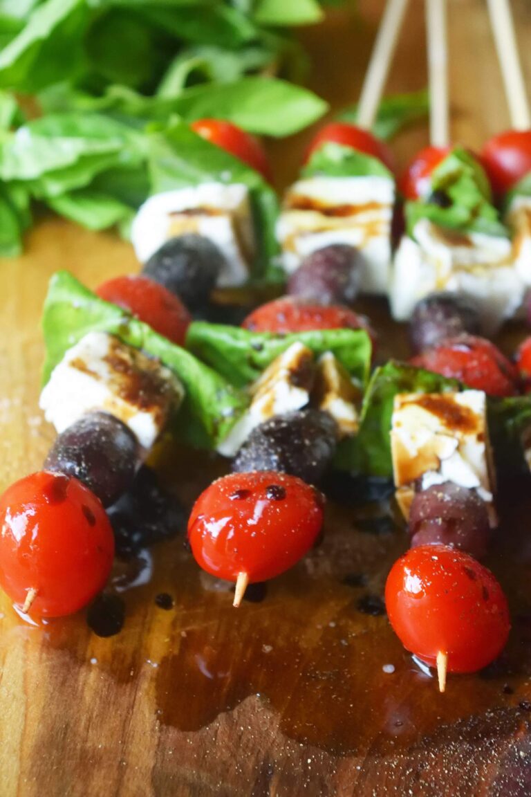 A front view of Mediterranean Skewers on a wood cutting board.