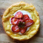 An overhead view of a yogurt cake on a wood surface.