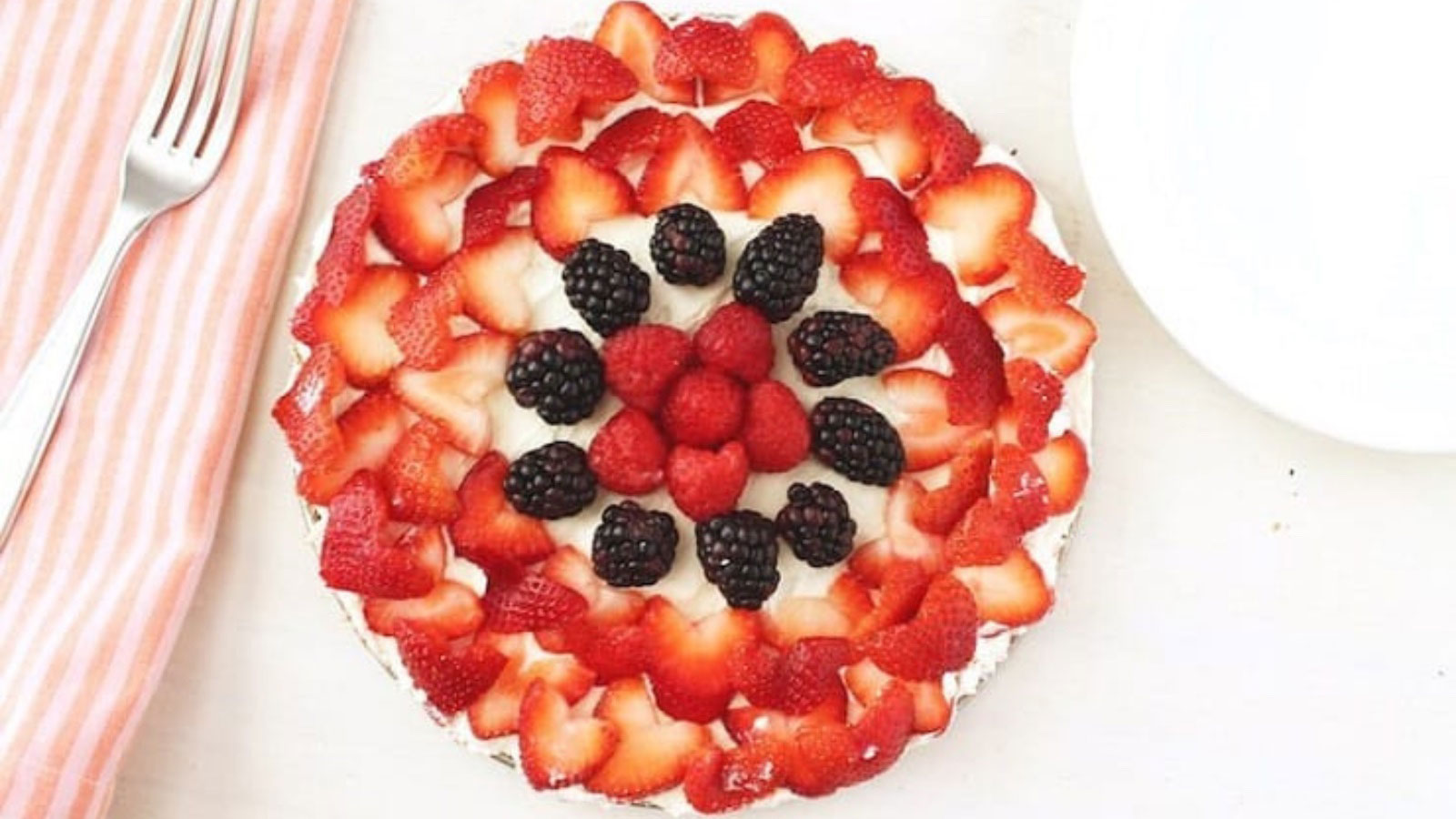 An overhead view of a cake covered in fresh berries.