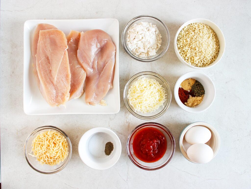 Air Fryer Chicken Parmesan Recipe ingredients on a white surface.