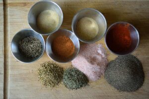 Blackening seasoning spices in individual containers on a cutting board.