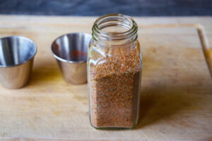 A glass spice jar filled with blackening seasoning.