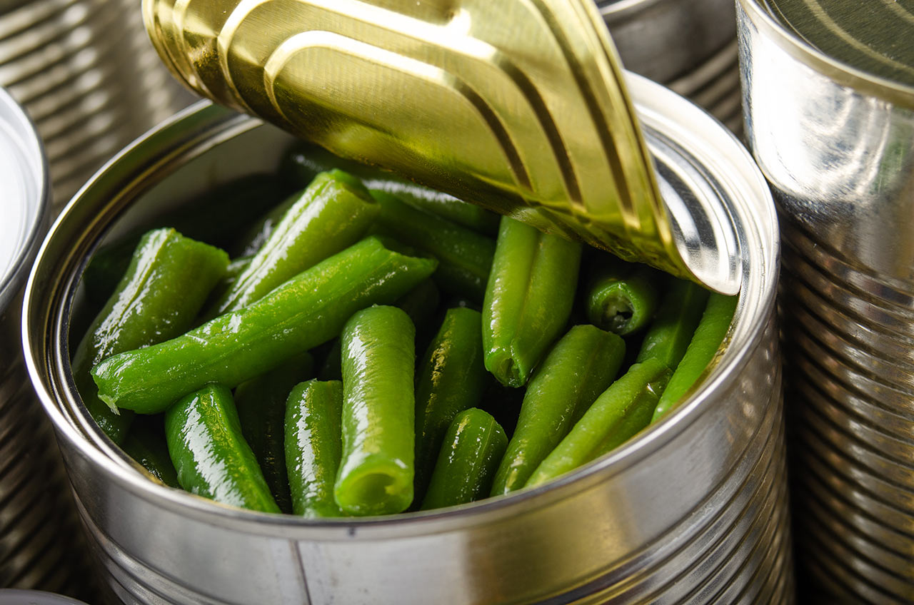 Canned green beans in just opened tin can.
