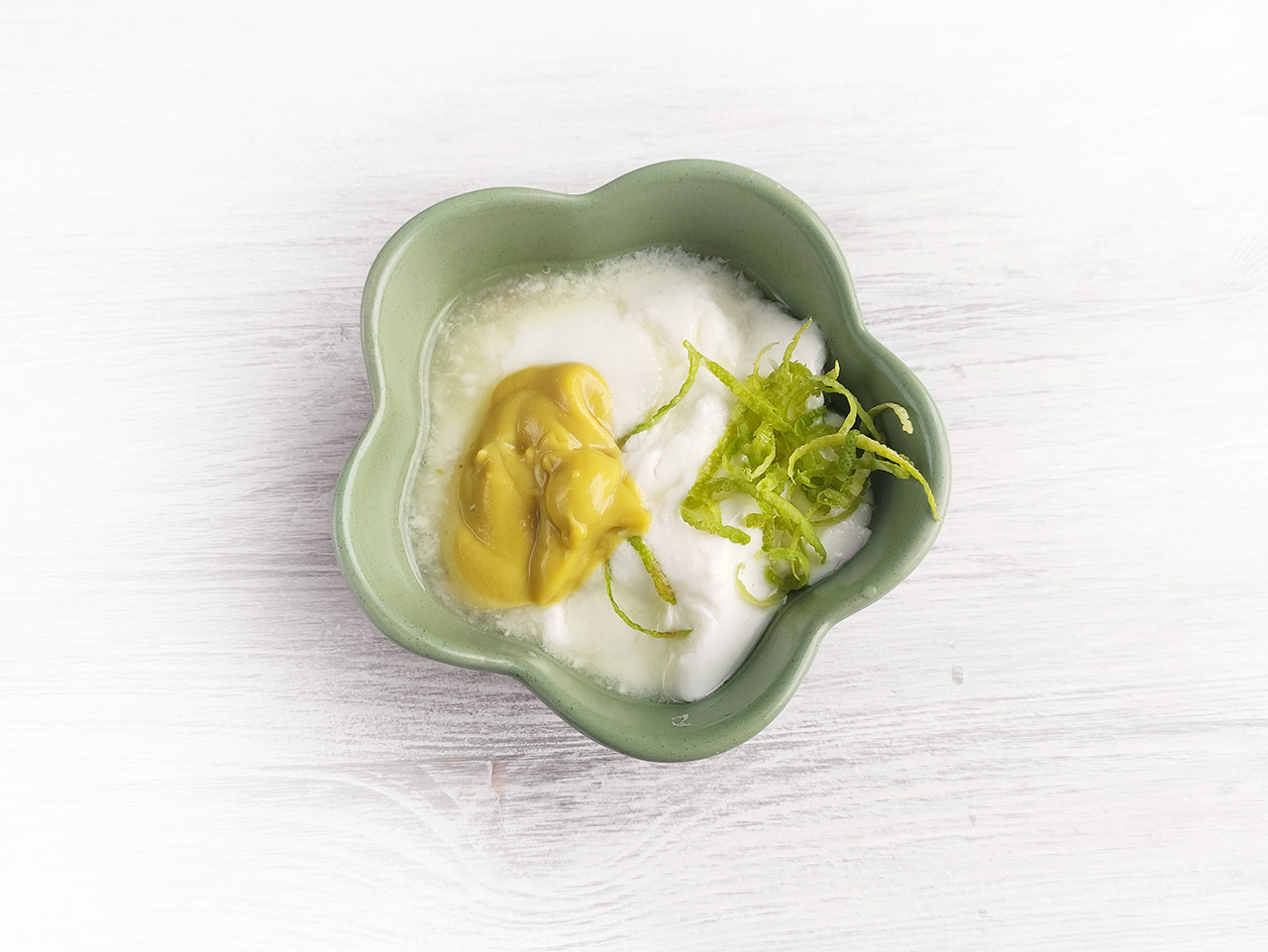 Dressing ingredients in a small, green bowl.