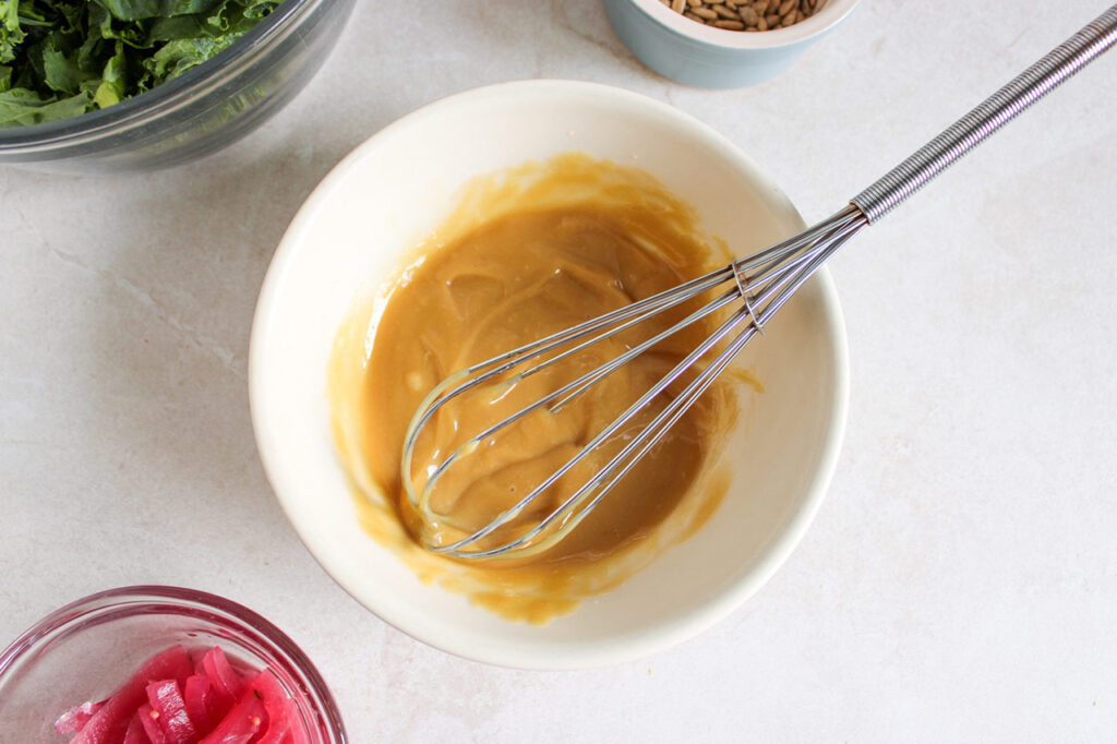 Tahini dressing mixed in a white bowl.