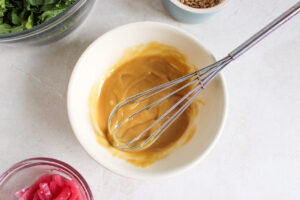 Tahini dressing mixed in a white bowl.