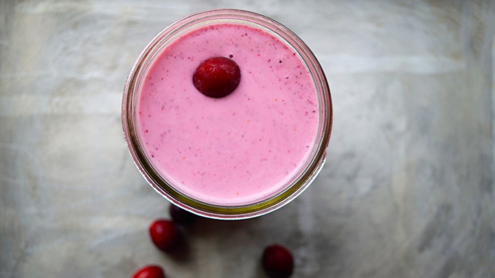 Overhead view of a glass full of fresh cranberry smoothie.