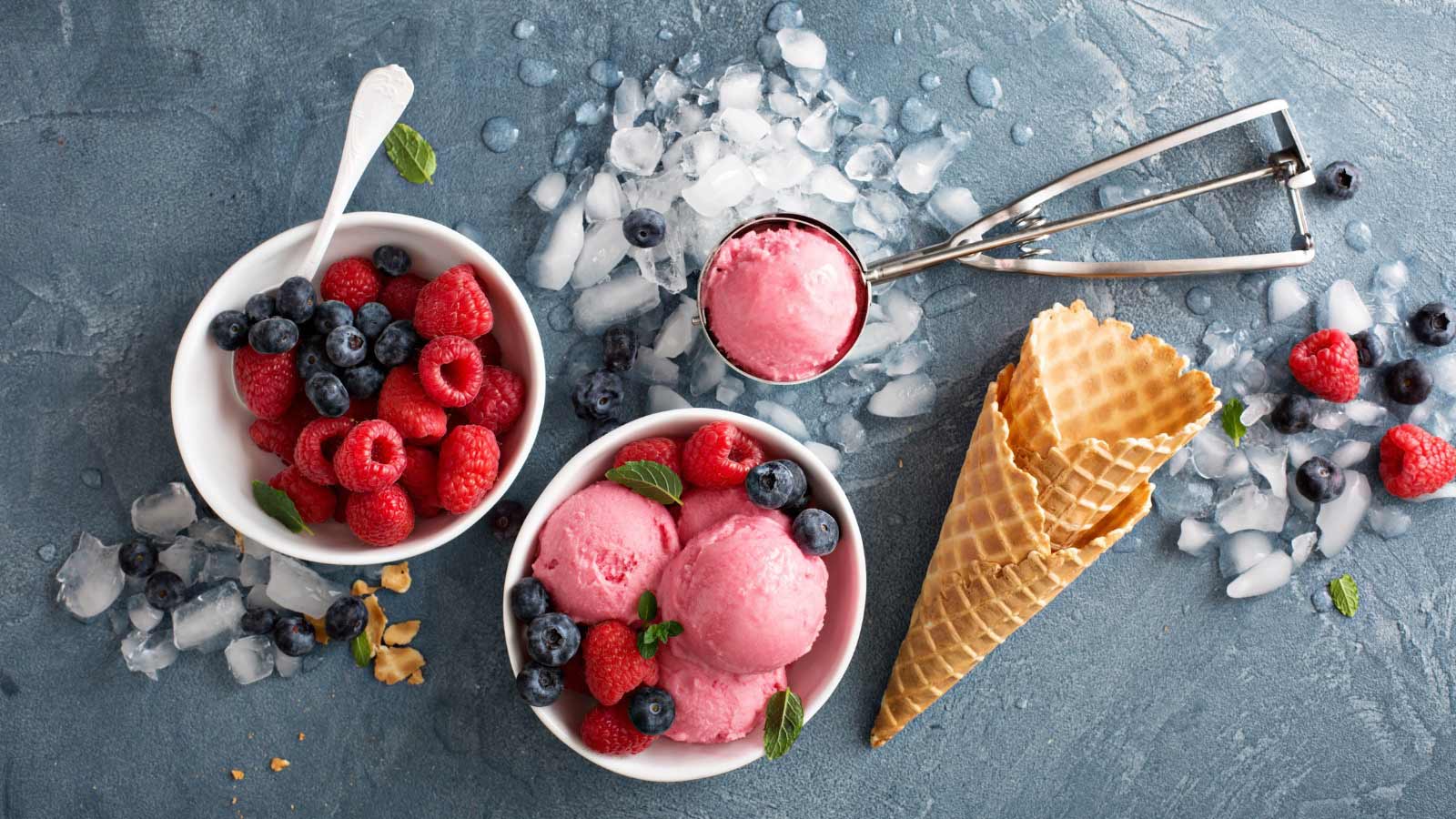 Raspberry ice cream in white bowl overhead shot.