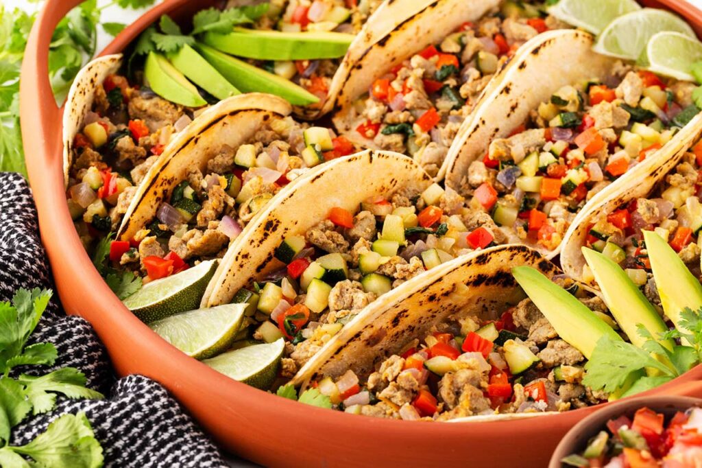 Healthy breakfast tacos lined up in a casserole dish.