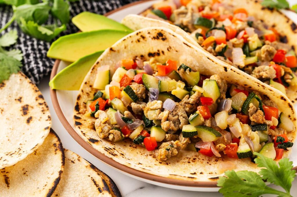 Focus on a single breakfast taco on a plate.