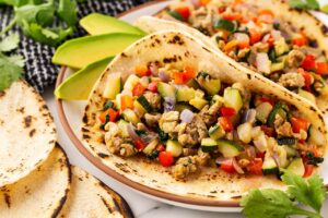 Focus on a single breakfast taco on a plate.