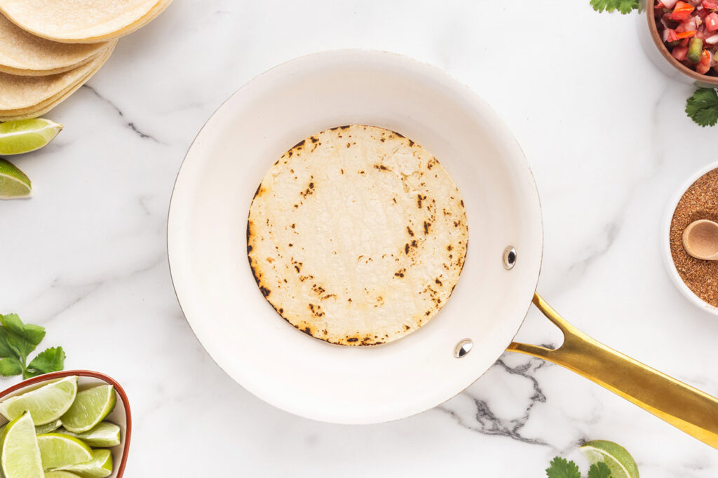 A single tortilla in a skillet.