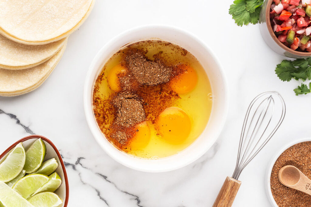 Eggs and spices in a white bowl.