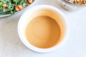 Tahini dressing in a small, white bowl.