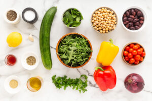 Mediterranean chopped salad ingredients on a white surface.