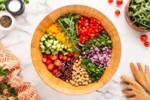 Mediterranean chopped salad ingredients in a wood salad bowl.