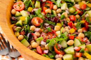 Closeup of a Mediterranean chopped salad in a wood salad bowl.