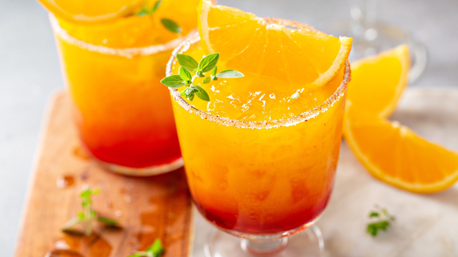 Tequila sunrise mocktail in different glasses with ice, refreshing summer drink.