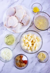 Ingredients for Moroccan chicken on a white, marble surface.