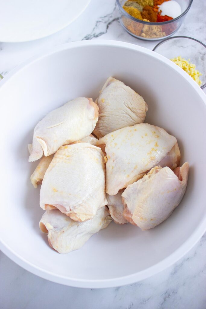 Raw chicken pieces in a bowl.