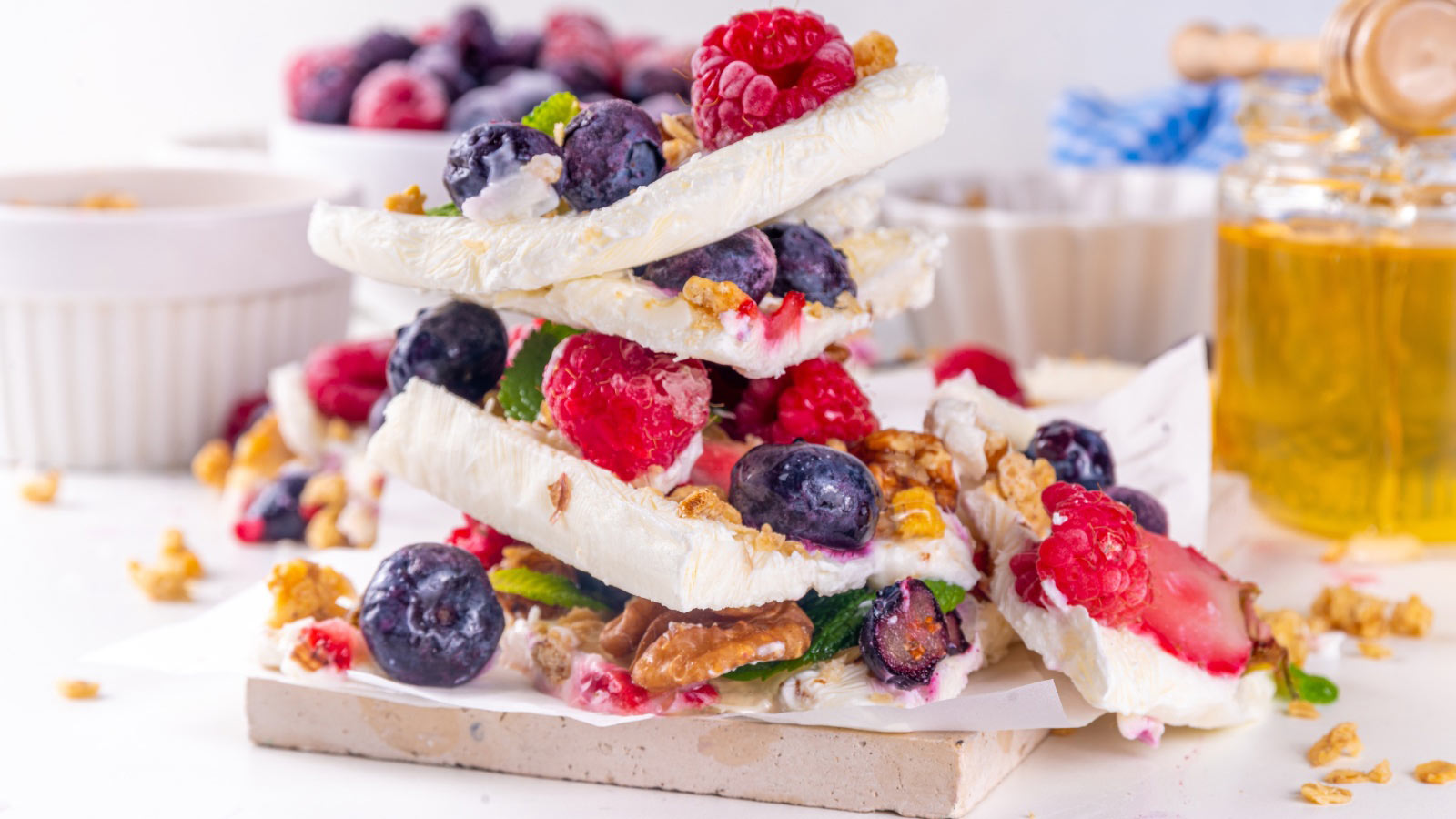 Homemade frozen Yogurt Bark, alternative healthy keto diet ice cream made from greek yogurt, fresh berries, nuts, granola, honey, on baking tray deco. Frozen yoghurt bars with fruit berry toppings.