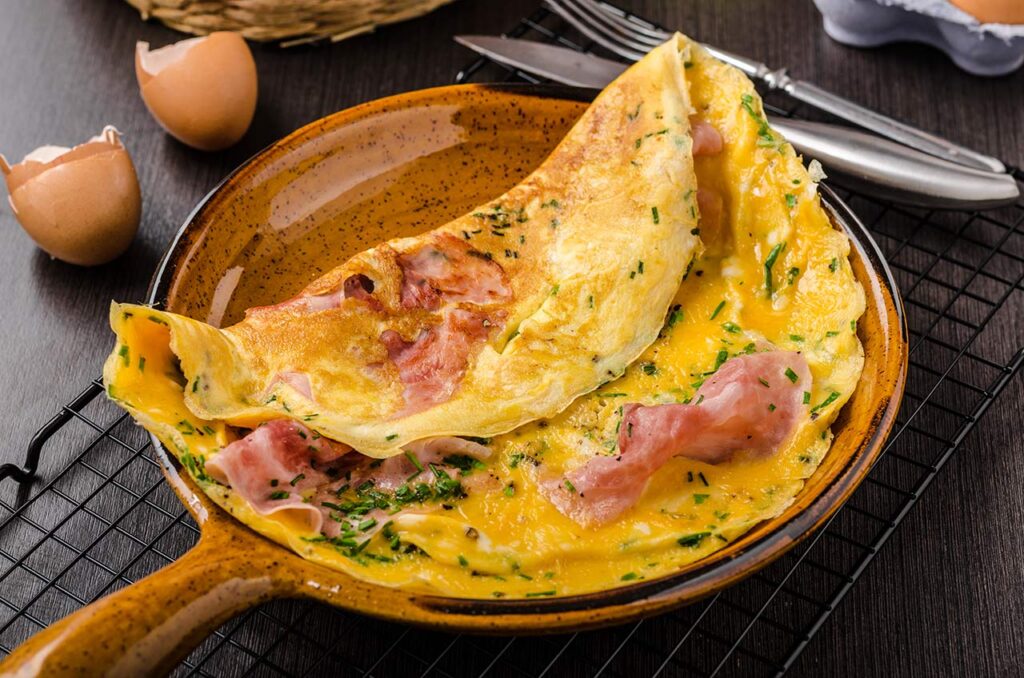 Ham and egg omelette, delicious and simple with fresh bread and herbs chive.
