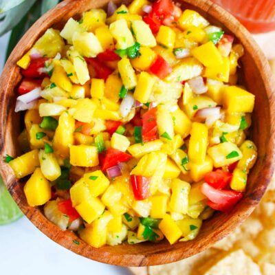 Full overhead view of a wood bowl filled with Pineapple Mango Salsa.