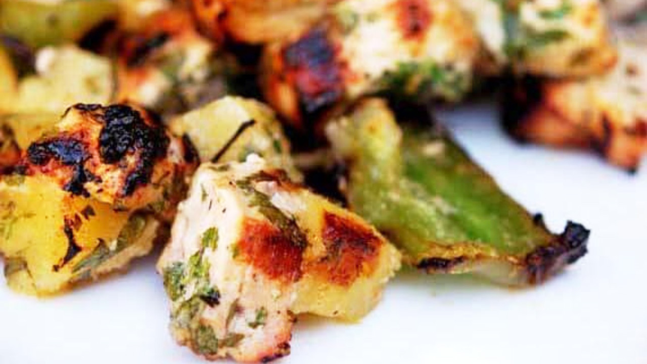 A closeup of disassembled Pineapple Pork Kebobs on a white plate.