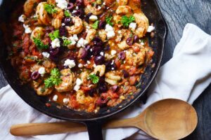 An overhead view of a skillet filled with Shrimp Saganaki.