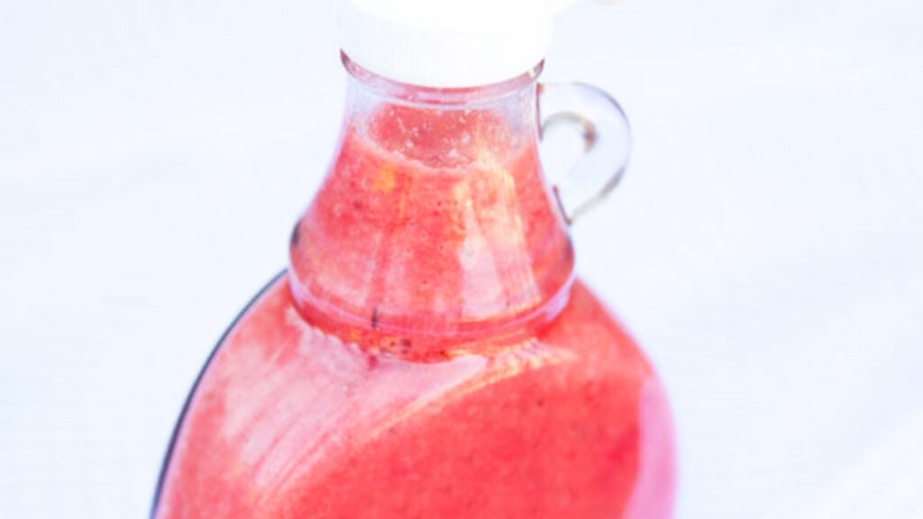 A closeup of a bottle of strawberry vinaigrette.