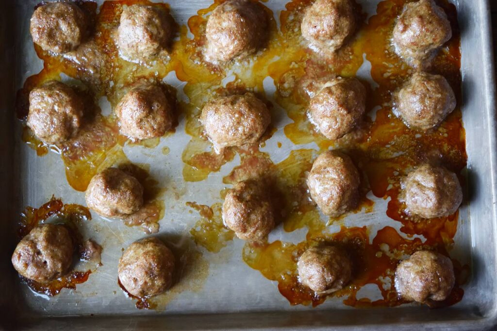 Baked turkey meatballs on a baking sheet.