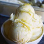 Front view of a white bowl filled with several scoops of Thai Coconut Ice Cream.
