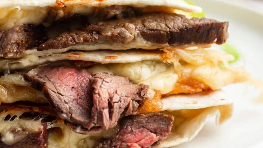 Closeup of a steak quesadilla stacked tall.